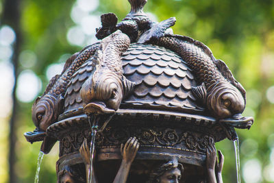 Low angle view of owl perching on statue