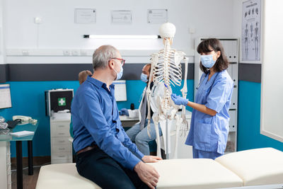 Nurse showing skeleton to patient
