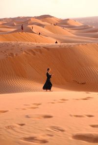 Full length of man on sand dune in desert