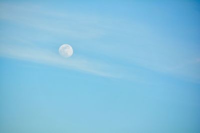 Low angle view of moon against blue sky