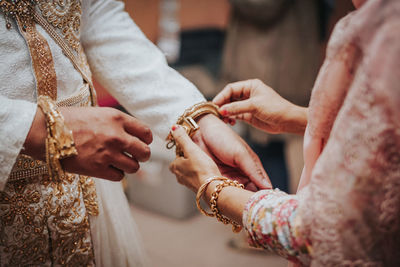 Midsection of couple holding hands