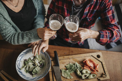 Senior couple drinking alcohol and preparing food