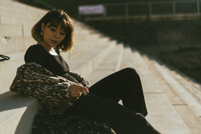 Midsection of woman sitting outdoors