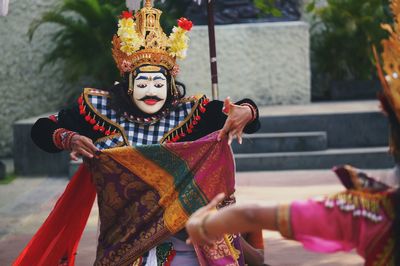 People dancing in traditional costumes on road