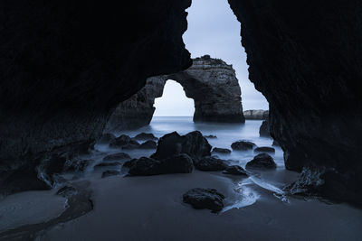 Rocks lying on beach in coastal cave, algarve