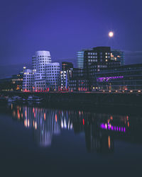 Reflection of illuminated buildings in city at night