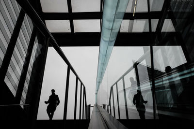 People walking on modern glass building in city