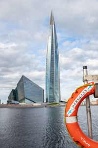 Scenic view of river by buildings against sky