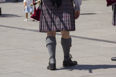 Low section of woman standing on street