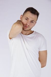 Portrait of young man standing against white background