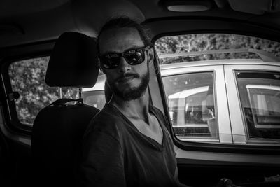 Portrait of man wearing sunglasses in car