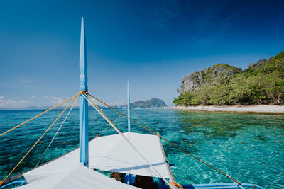 Sailboat sailing on sea against blue sky