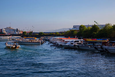 Boats moored in sea against clear sky