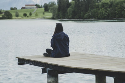 Woman sitting on a pier at a lake