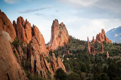 Rock formations in forest against sky