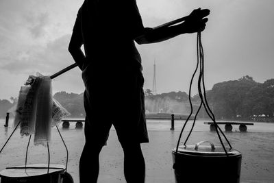 Low section of a man selling silken tofu standing by during the rainy season