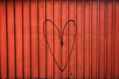 Full frame shot of red metal fence against wall