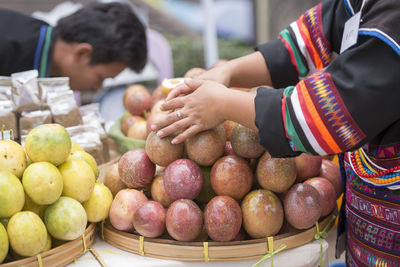 Midsection of woman picking fruits from market stall