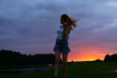 Rear view of woman with umbrella against sky