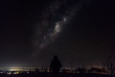 Silhouette buildings against sky at night