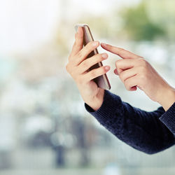 Cropped hands of woman using mobile phone
