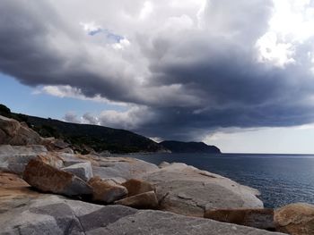 Rocks on sea shore against sky