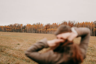 Atmospheric photo of a girl in the autumn forest. defocusing the foreground. brown tones. 