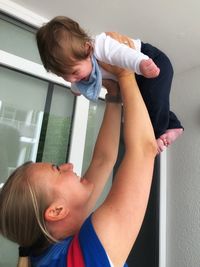 Mother playing with son at home