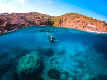 Woman underwater with blue sea in sardinia