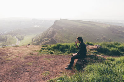 Side view of man looking at mountain landscape