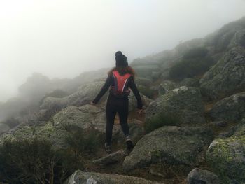 Hiking  a rocky mountain on a foggy day