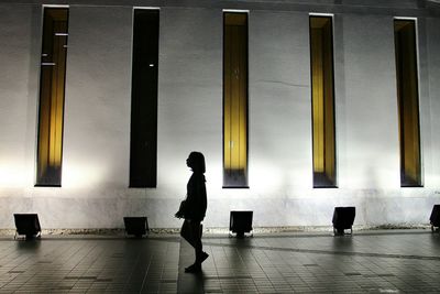 Silhouette woman walking at art museum
