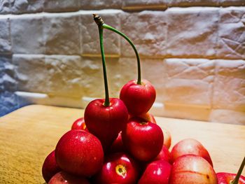 Close-up of cherries on table against wall