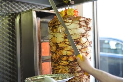 Close-up of hand cutting kebab