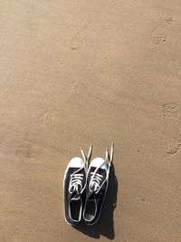 Directly above shot of canvas shoes at sandy beach 