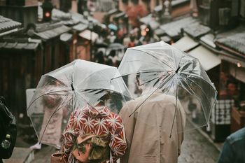 Rear view of people walking on street during rainy season