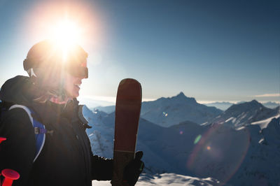 Low angle view of woman standing on mountain against sky during sunset