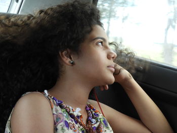 Girl with curly hair sitting in car