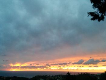 Scenic view of sea against cloudy sky at sunset