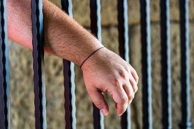 Close-up of hand on metal fence