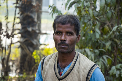 Portrait of man standing against plants