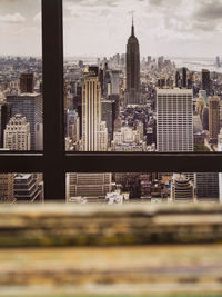 Pile of vinyl record sleeves in apartment with nyc skyline in background