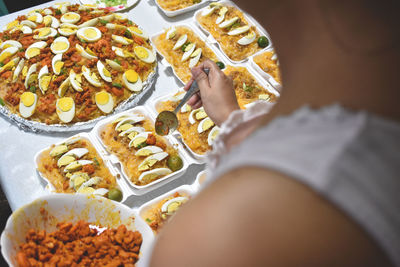 High angle view of person holding bread in plate on table