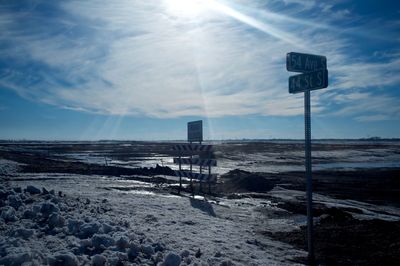 Signboards on street against sky during winter