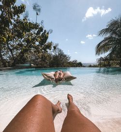 Low section of woman relaxing in swimming pool