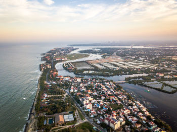 High angle view of buildings by sea against sky