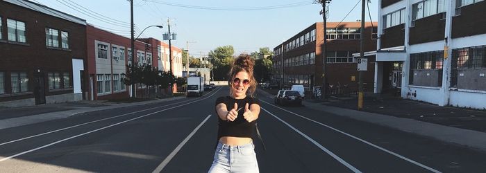 Young woman standing on walkway against sky
