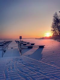 Scenic view of snow covered land during sunset