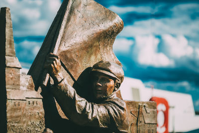 Close-up of statue by sea against sky