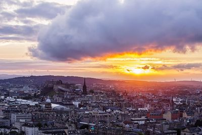 Aerial view of city against cloudy sky during sunset